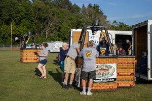 Row of vendor booths and food trucks serving customers at an outdoor festival.