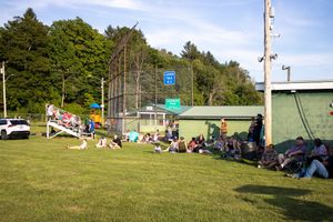 Panoramic view of a festival ground with scattered tents and vehicles on a hillside.