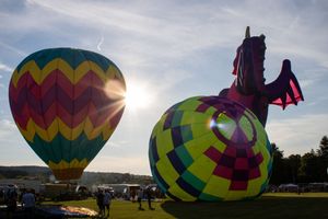 Silhouettes of hot air balloons against sunset sky with geometric patterns and vibrant colors.
