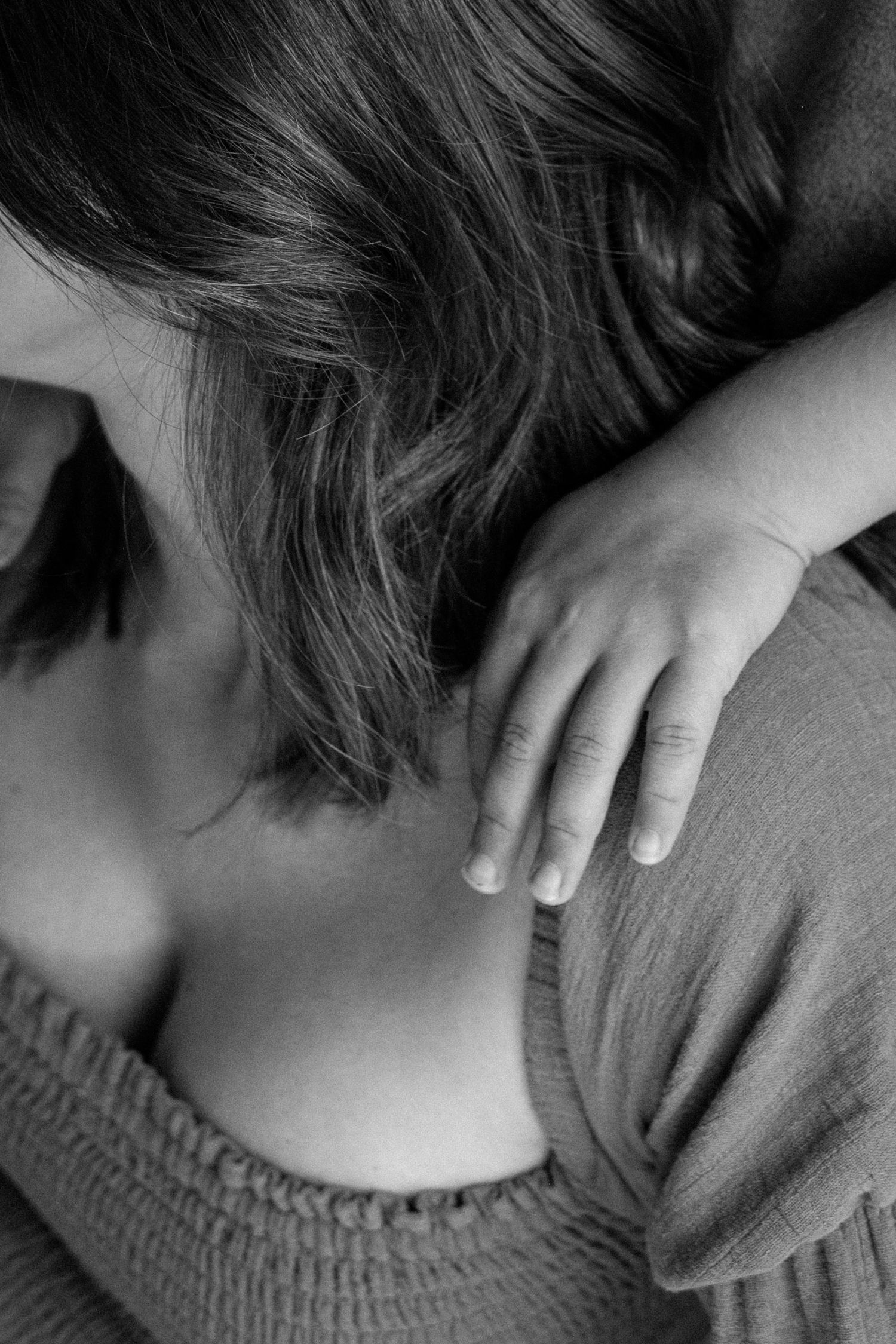 A close-up sequence showing hands massaging a person's shoulder and neck area in black and white format.