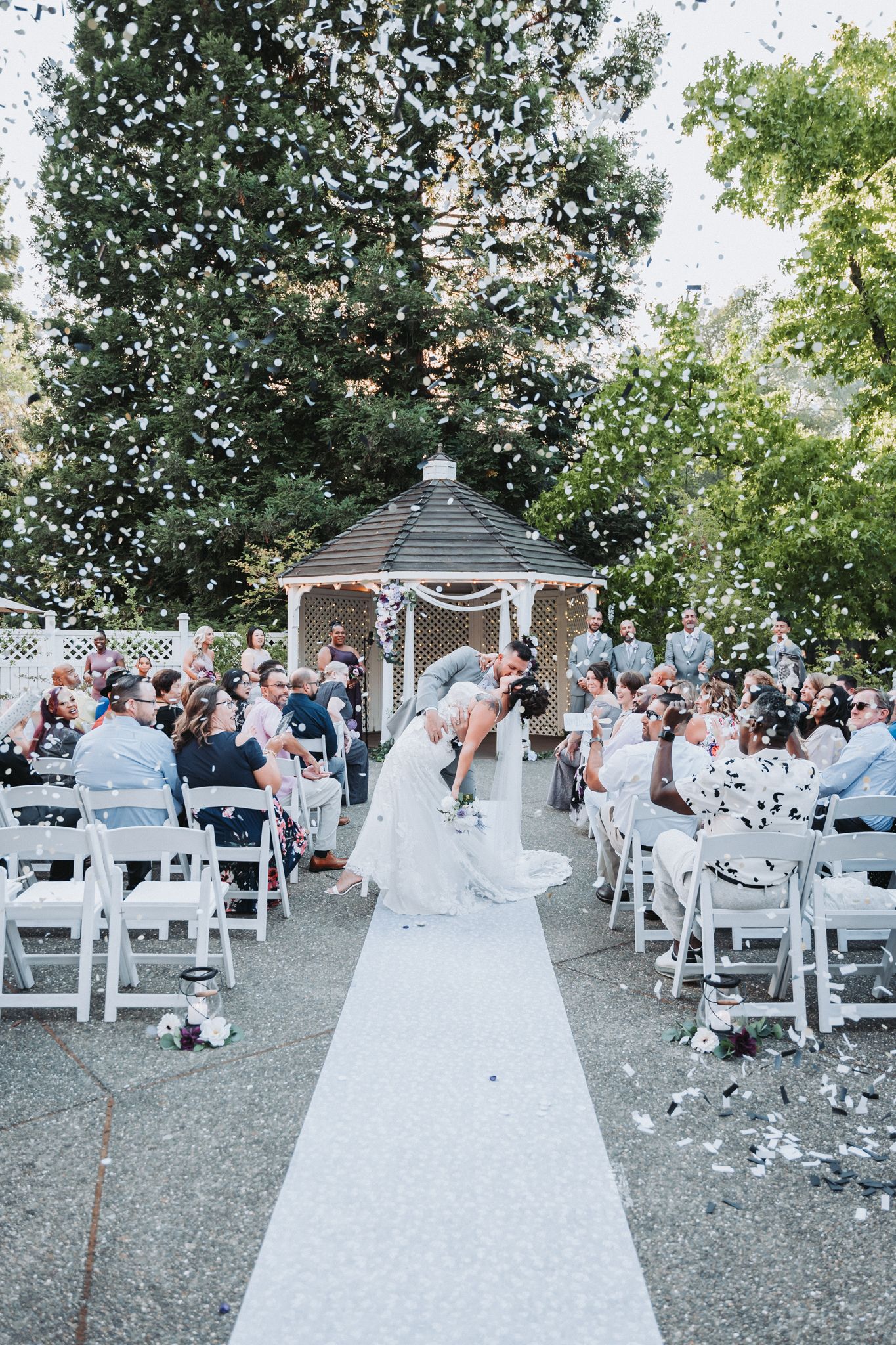 Bride and groom kissing while walking down aisle at wedding ceremony in Omaha, NE.