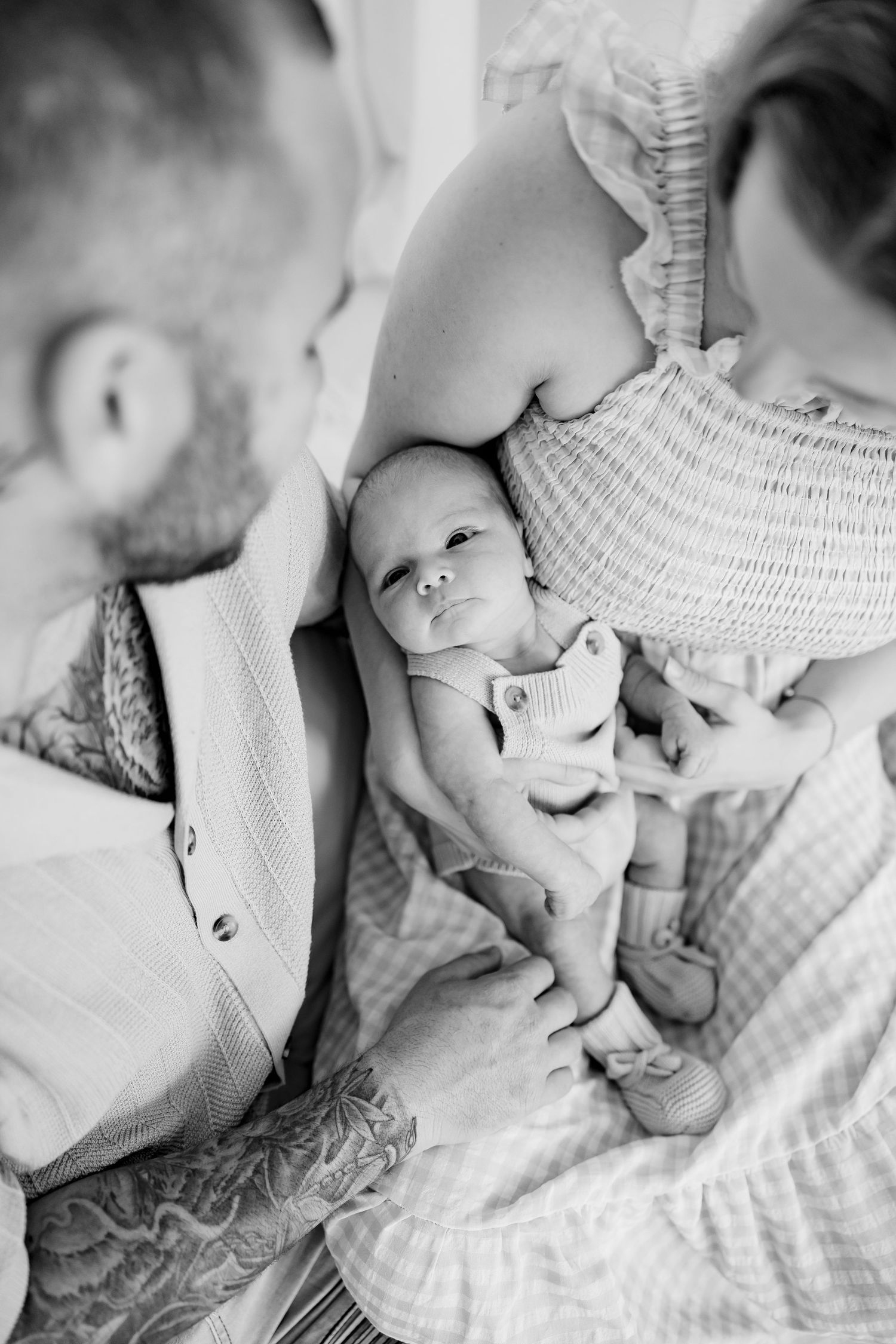 Black and white newborn photo sequence showing tiny feet and hands against soft white bedding.