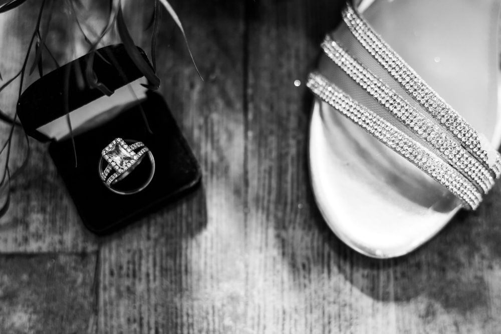 A series of eight black and white photos showing cosmetic products and makeup tools arranged on a rustic wooden surface.