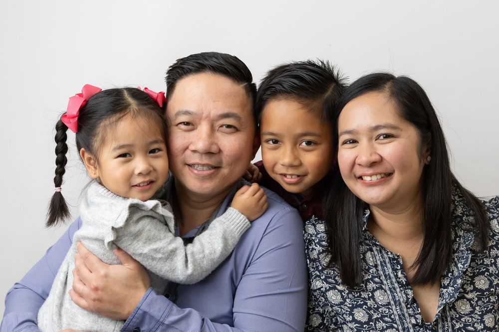 Asian family poses together for professional portraits in coordinated outfits.