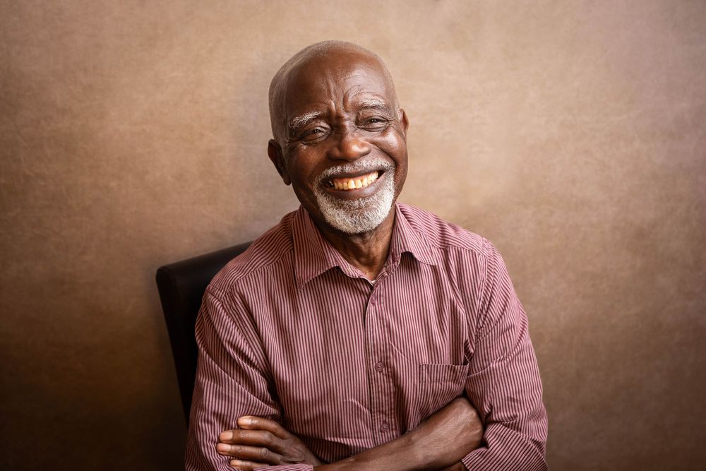 Professional headshot series of person in pink shirt against neutral brown background.