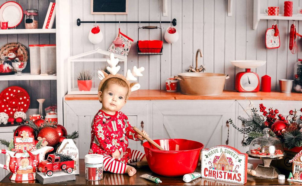 Festive red and white Christmas holiday decor display with pillows, stockings, and ornaments on white wood paneled walls.