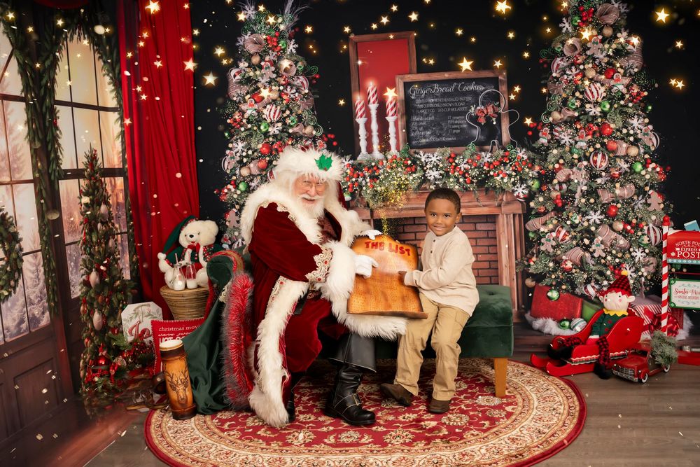 Holiday portrait setup with beautifully decorated Christmas trees, red drapes, and twinkling lights in a cozy indoor setting.