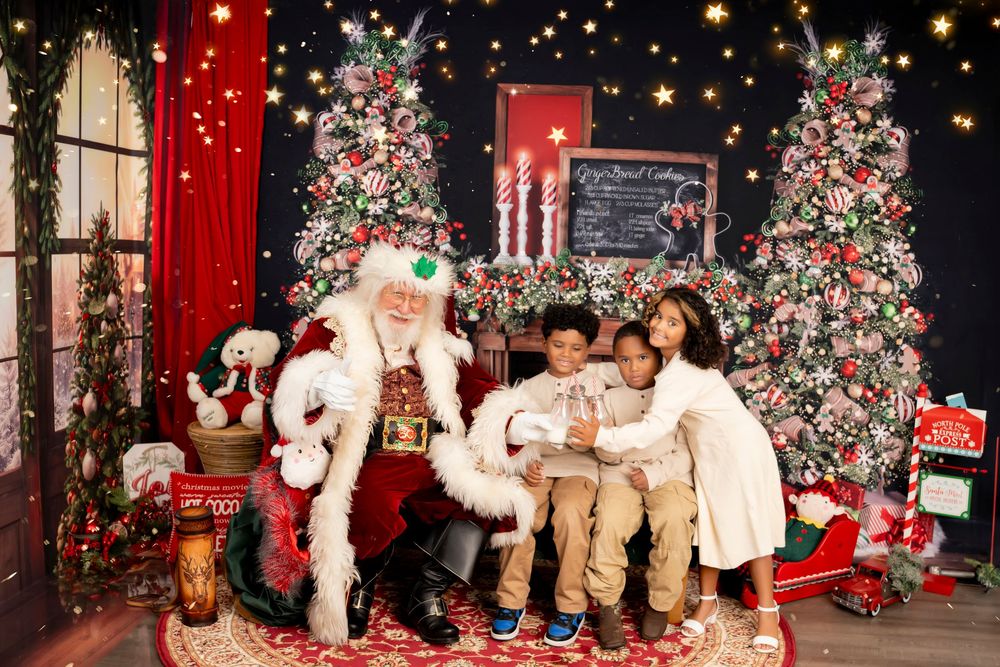 Holiday photo session scene with decorated Christmas trees, presents, and cozy red and white decor in a professional studio setup.