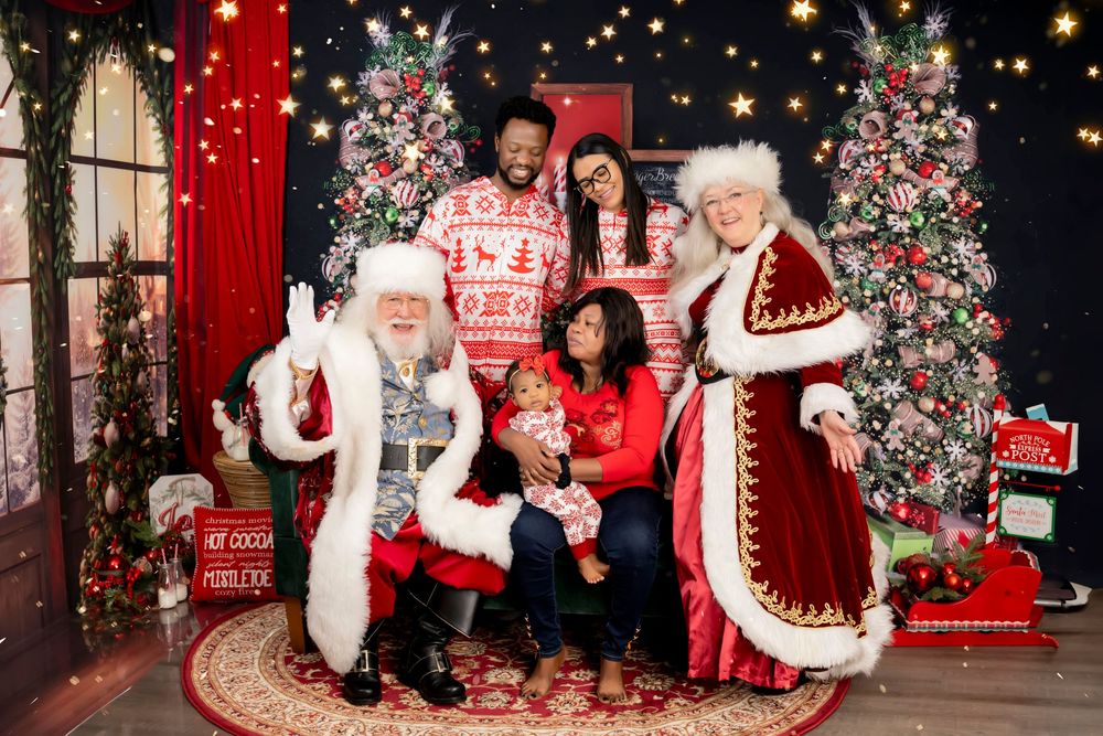 Holiday photos captured in a bright decorated Christmas setting with festive red backgrounds and twinkling lights.