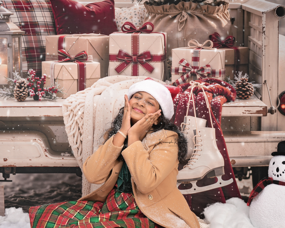 Woman in Santa hat dreamily posing among Christmas gifts and decorations in a festive holiday scene.