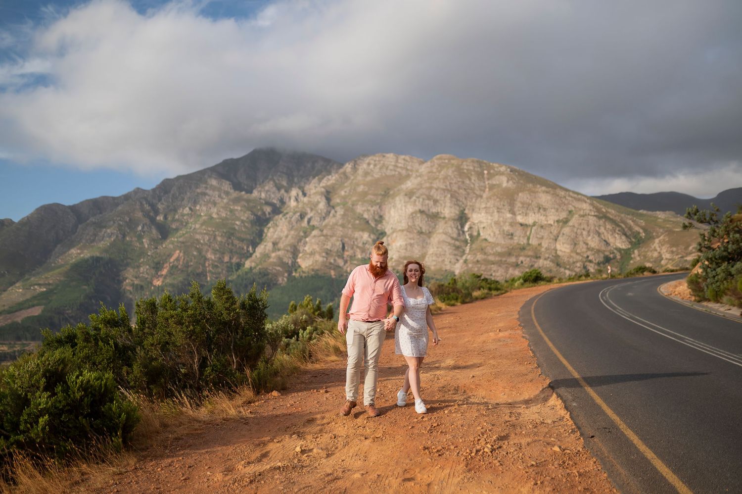 Scenic coastal mountain highway curves along rugged cliffs with dramatic ocean views in Maui, Hawaii at sunset.