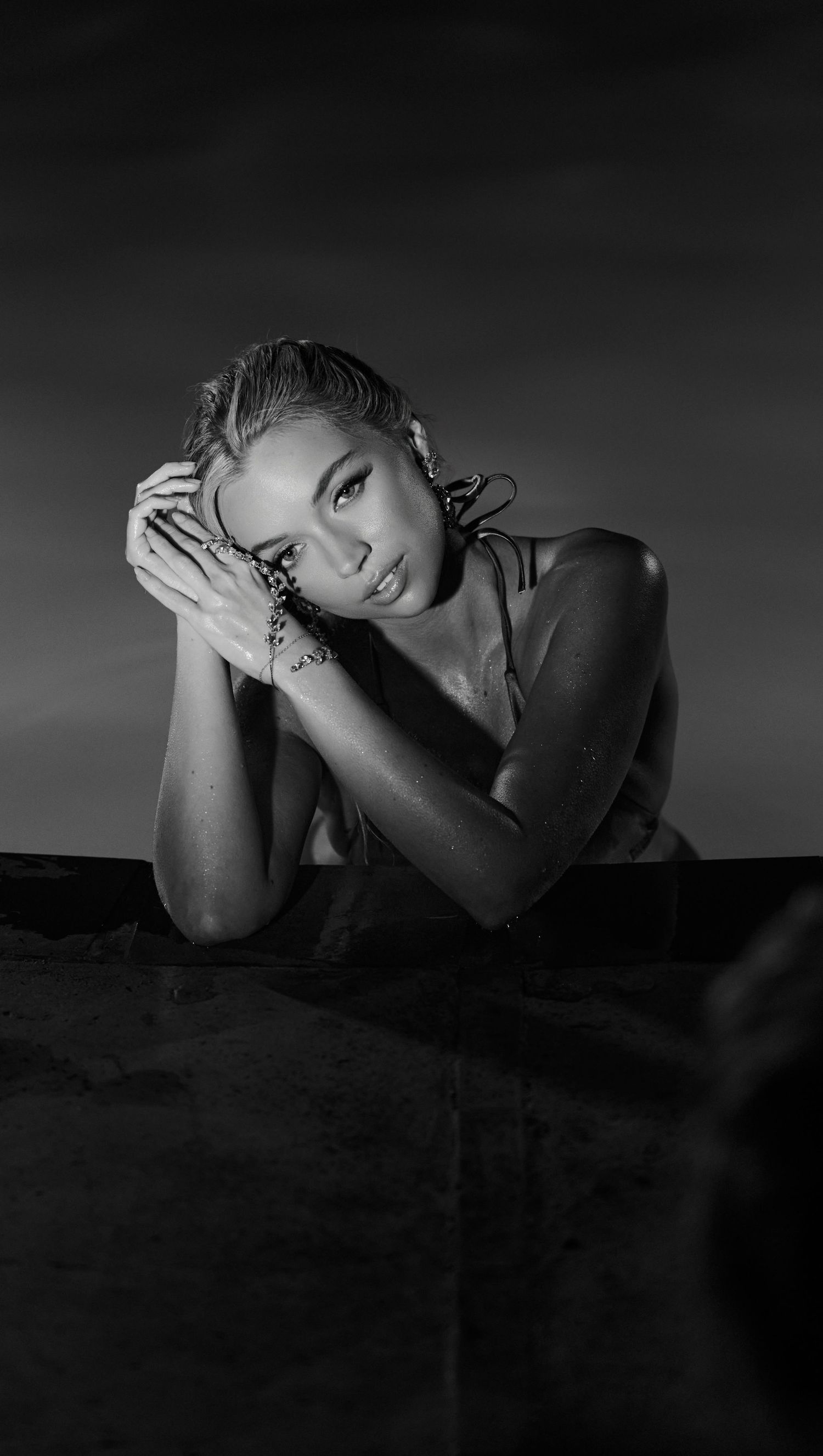 Artistic black and white portrait photograph showing dramatic shadows and poses in moody lighting.