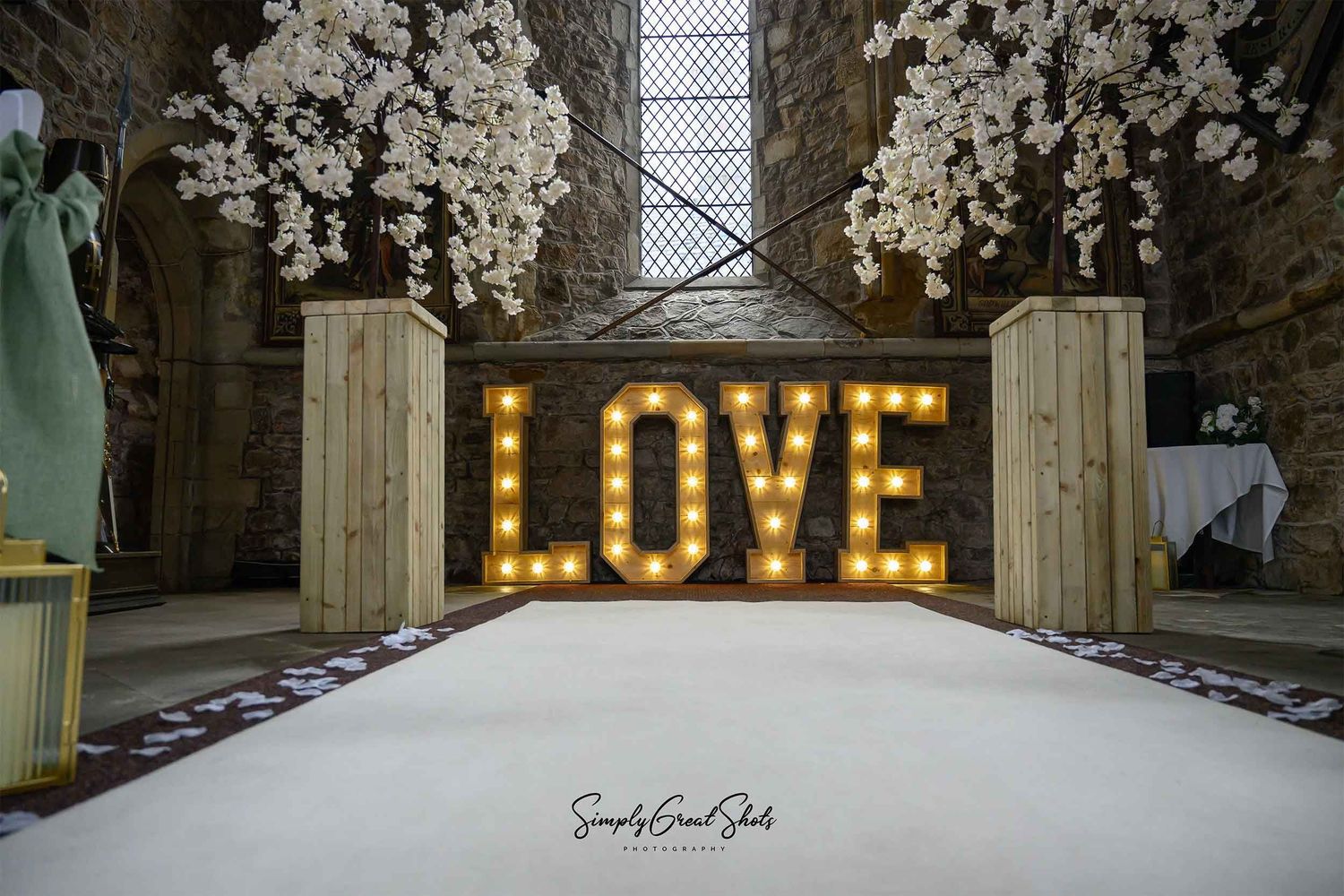 Rothley Court Hotel wedding photographer documenting chapel ceremony with illuminated love sign