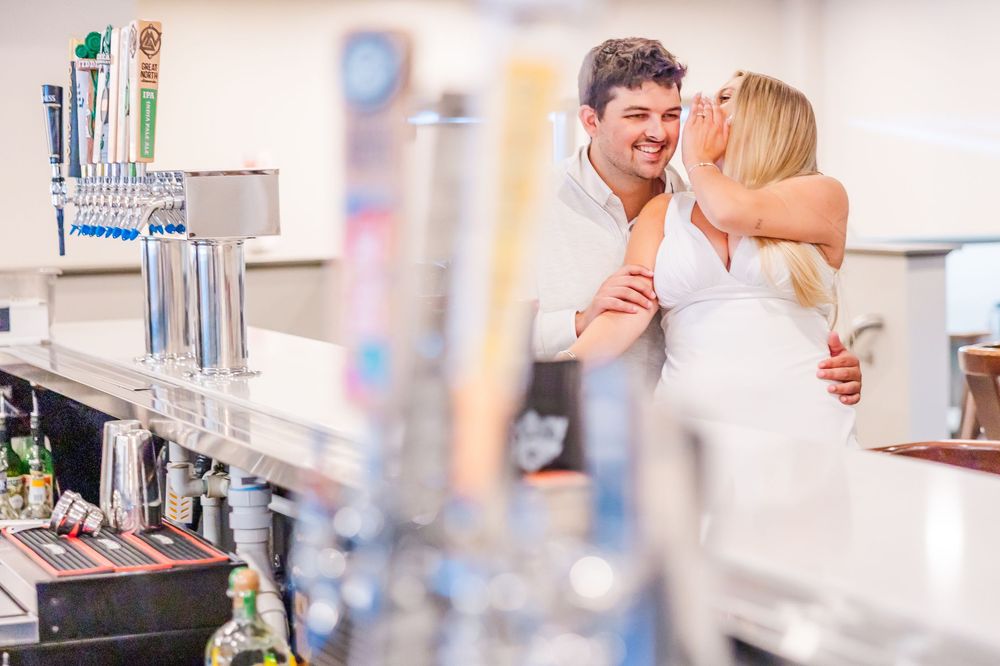 A romantic couple shares an intimate moment while drinking at an upscale bar.