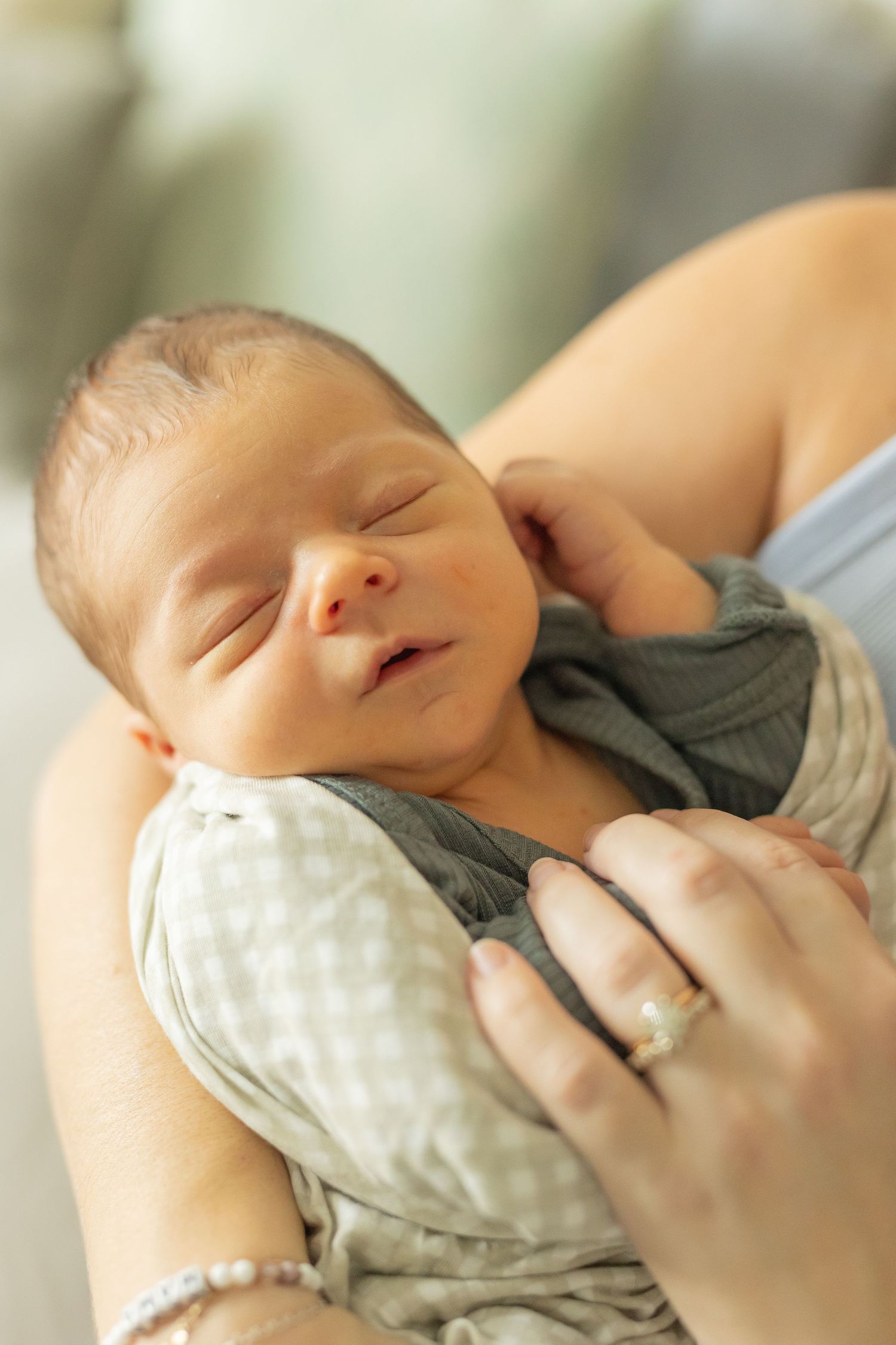 Sleeping baby boy held in his mother's arms