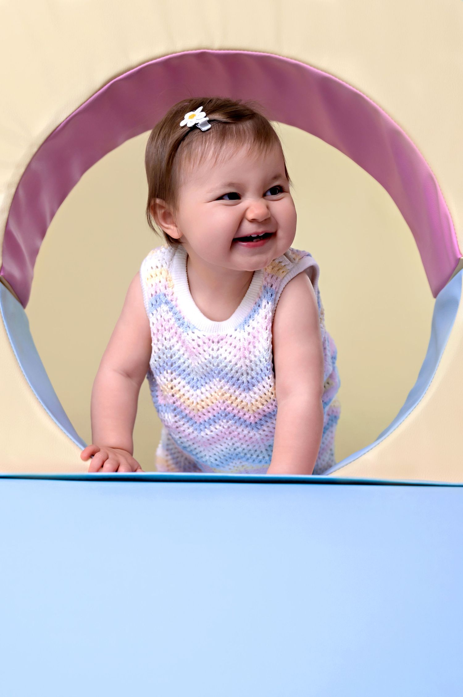 Toddler girl taking first steps on pastel soft play blocks in Suffolk photography studio
