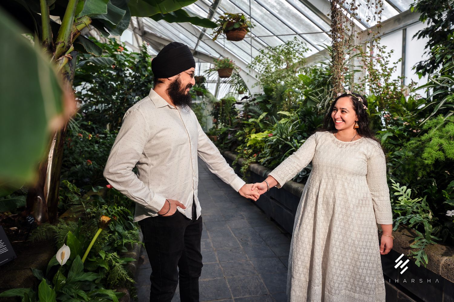 A romantic greenhouse engagement session with soft natural lighting and tropical plants.
