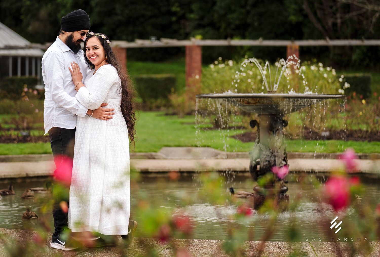 A joyful moment shared between two people in a blooming garden setting.