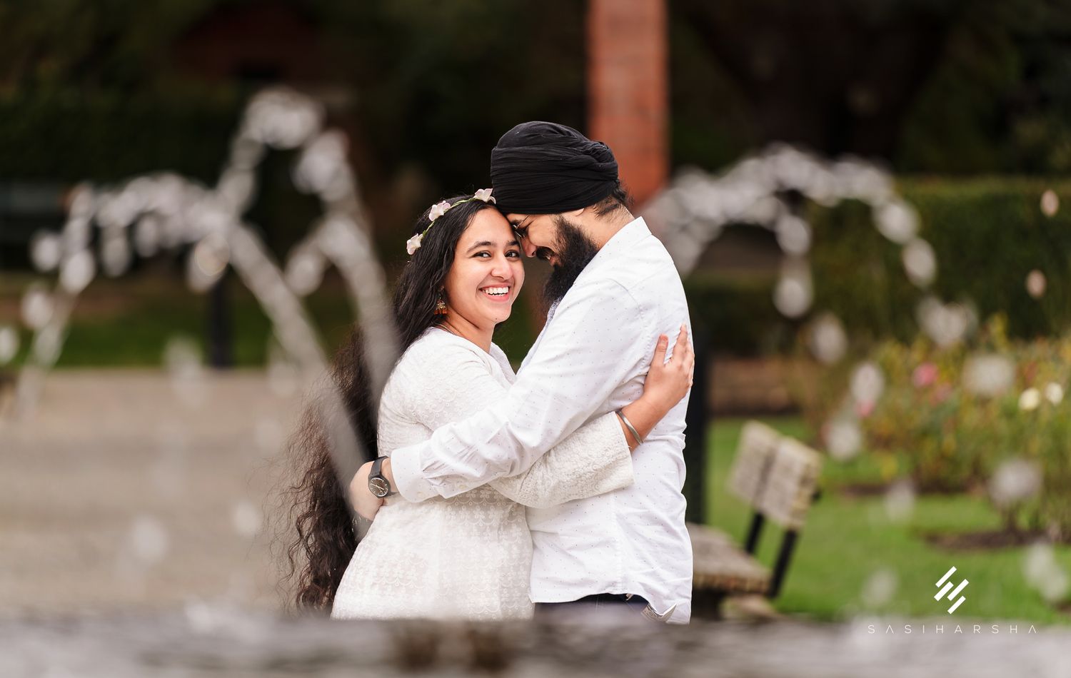 A loving embrace captured in a garden setting with soft natural lighting.