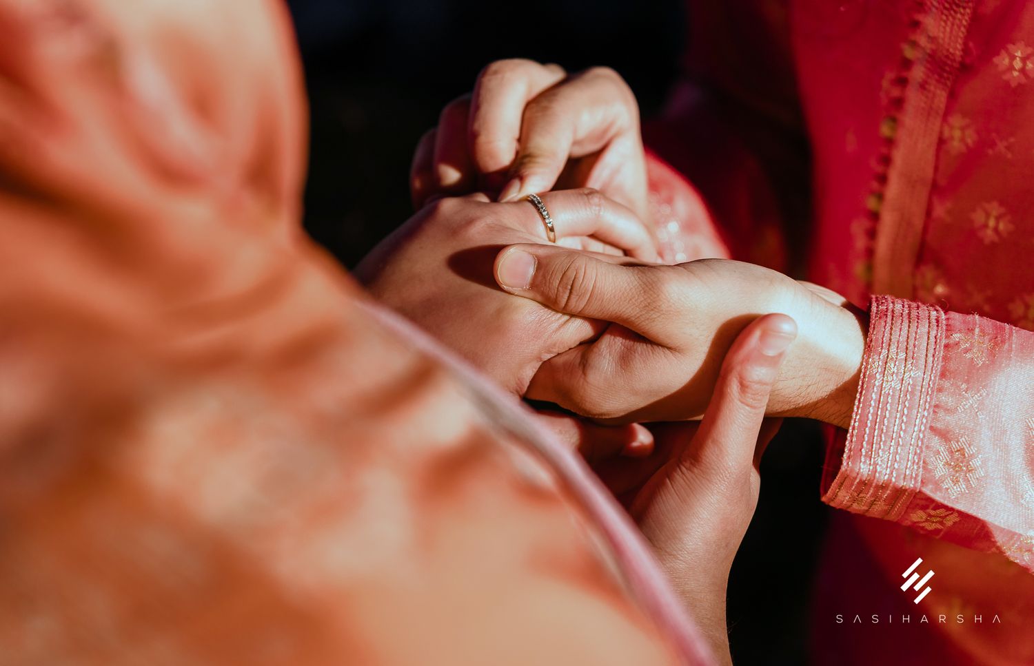 Close-up of hands during a ring exchange ceremony.