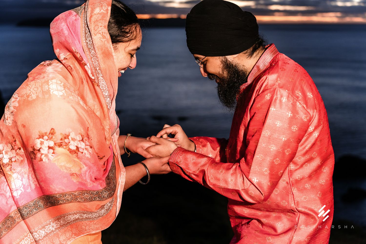 A traditional ring ceremony at sunset by the ocean.