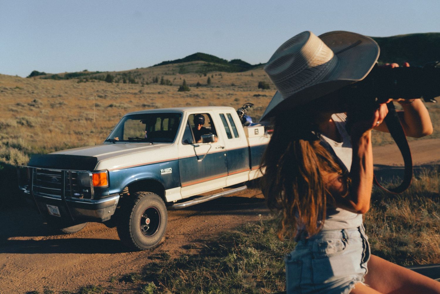 Claire Lichtwardt photographing a sunset shoot with a 1990 F150 driving in the background