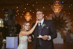 Dancing couples celebrate at a barn wedding reception under warm lighting.
