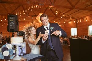 Wedding reception venue decorated with warm string lights and rustic wooden interior.