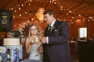 Wedding celebration inside rustic barn venue with romantic string light ambiance.