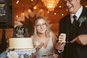 Wedding reception guests laugh and celebrate under warm chandelier lighting during an indoor celebration.