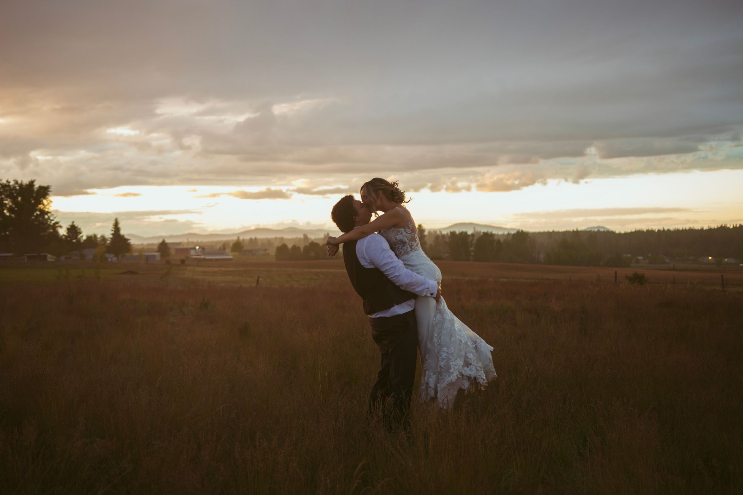 Scenic series of landscape photos showing a romantic couple embracing at sunset in a rural field setting.