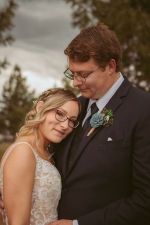 Intimate wedding portrait captures tender moment between couple in natural lighting.