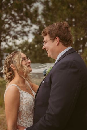 A happy wedding couple shares a joyful moment together during their outdoor wedding photoshoot.