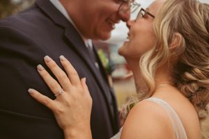 Romantic intimate moment between couple during outdoor wedding ceremony.