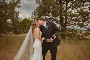 Romantic outdoor wedding portraits with couple embracing in natural setting.