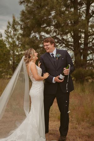 Candid wedding couple moments captured during their first look in a rustic outdoor pine forest setting.