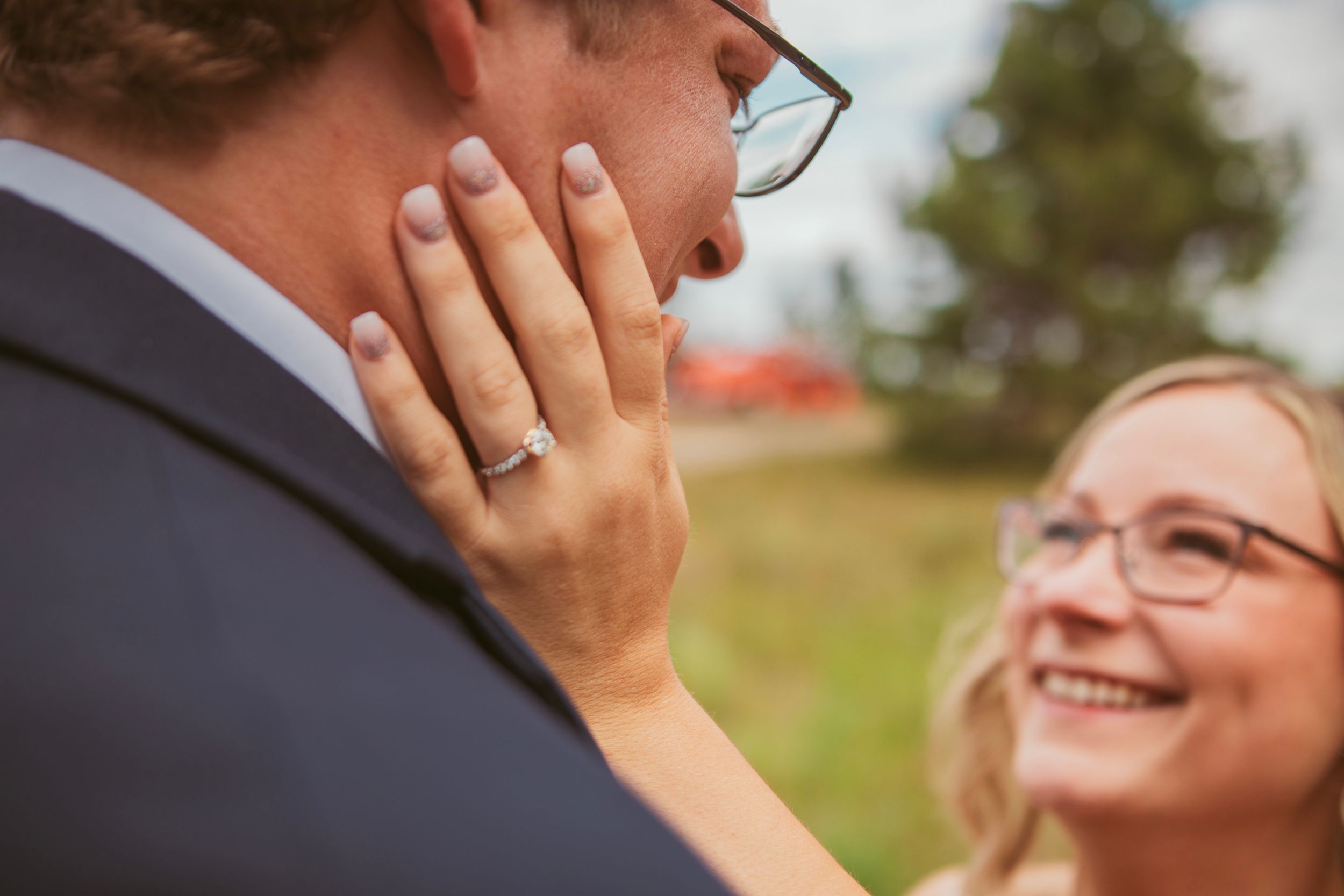 Close up of newly married couple sharing an intimate moment wearing glasses and wedding rings.
