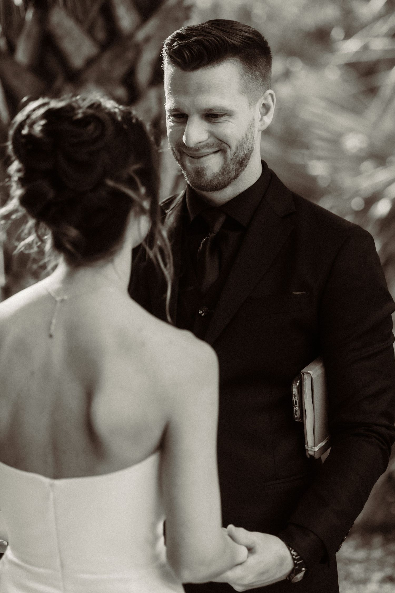 A black and white photo capturing an intimate wedding moment between a couple during their ceremony.