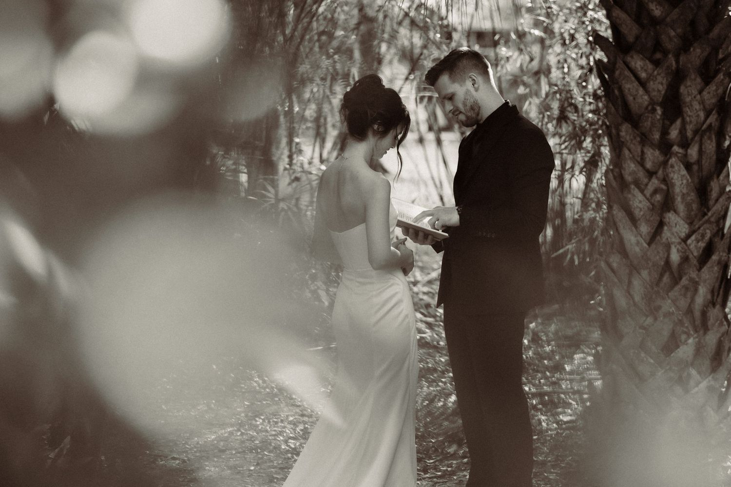 A romantic woodland wedding ceremony captured through dreamy bokeh effects and soft lighting in a natural forest setting.