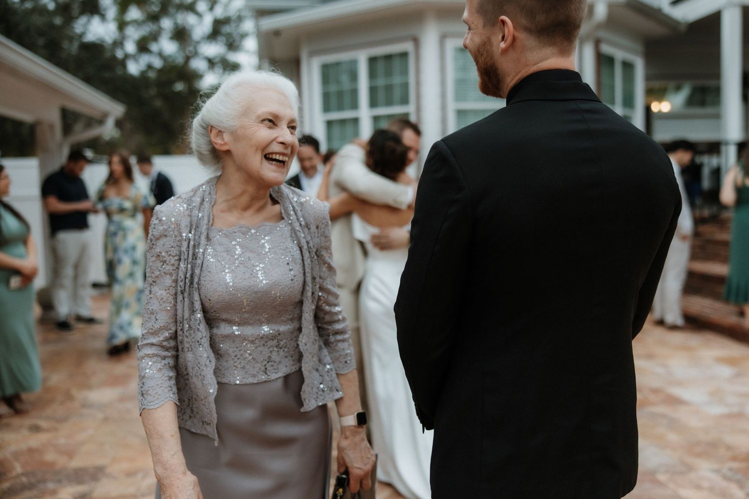 A heartwarming moment shared between wedding guests during an outdoor celebration.