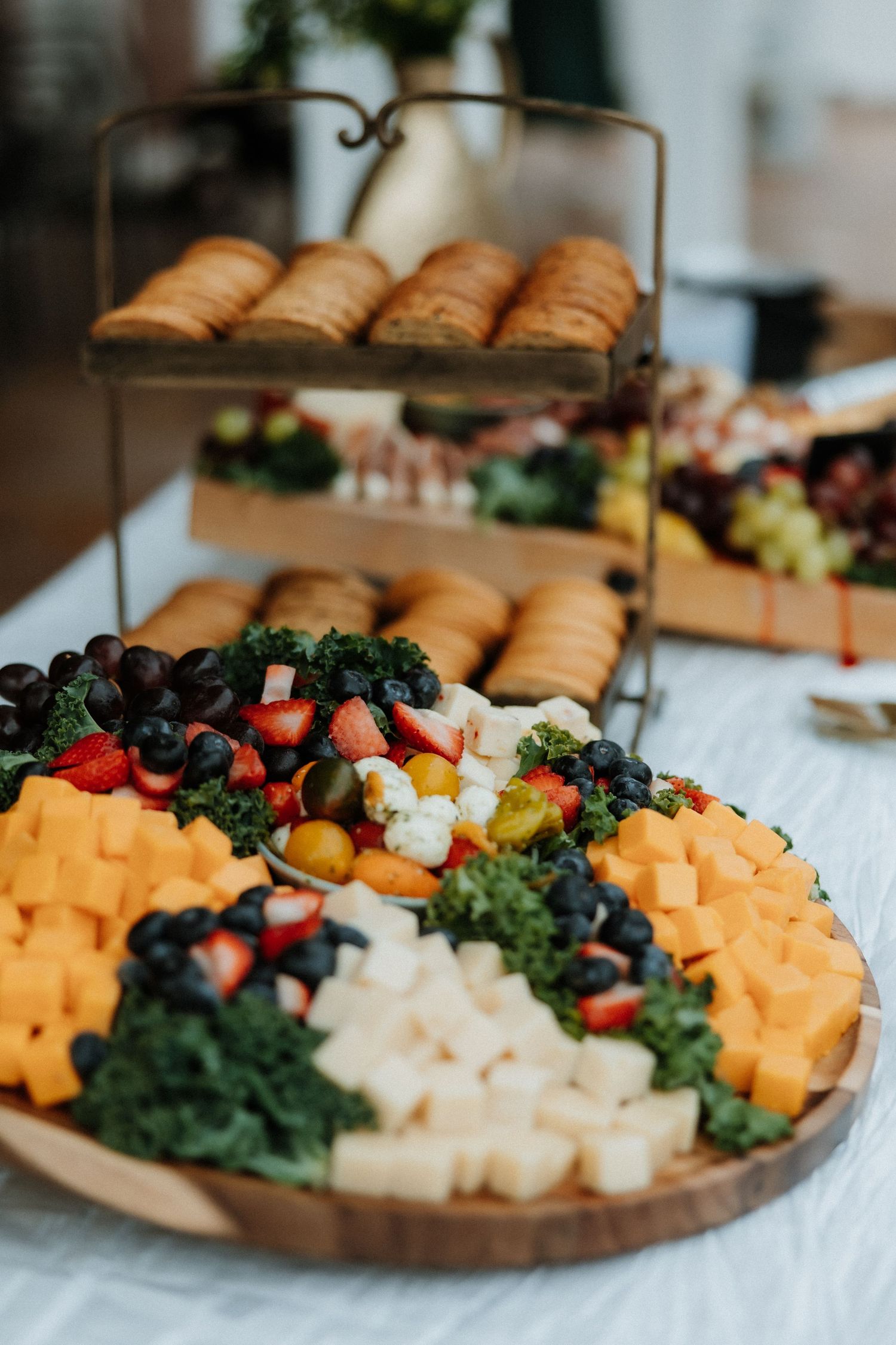 A charcuterie board with an assortment of cheese, berries, and fresh fruits arranged artistically.