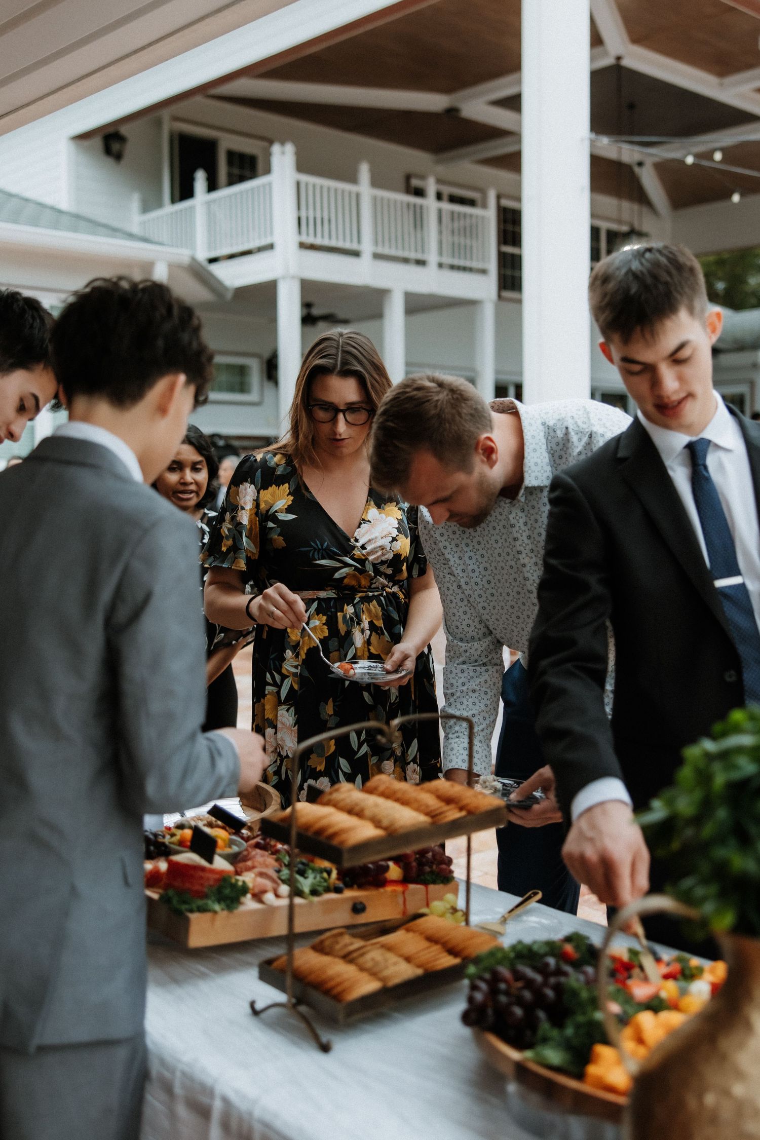 Guests gathering around an elegant buffet table with food displays at an upscale event.