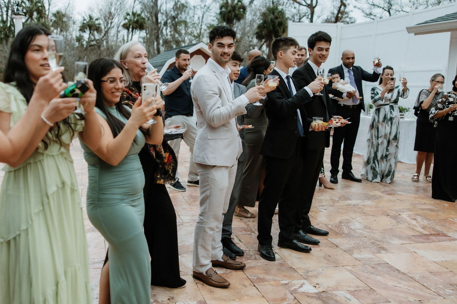 Wedding guests enjoying the reception while taking photos with their phones.