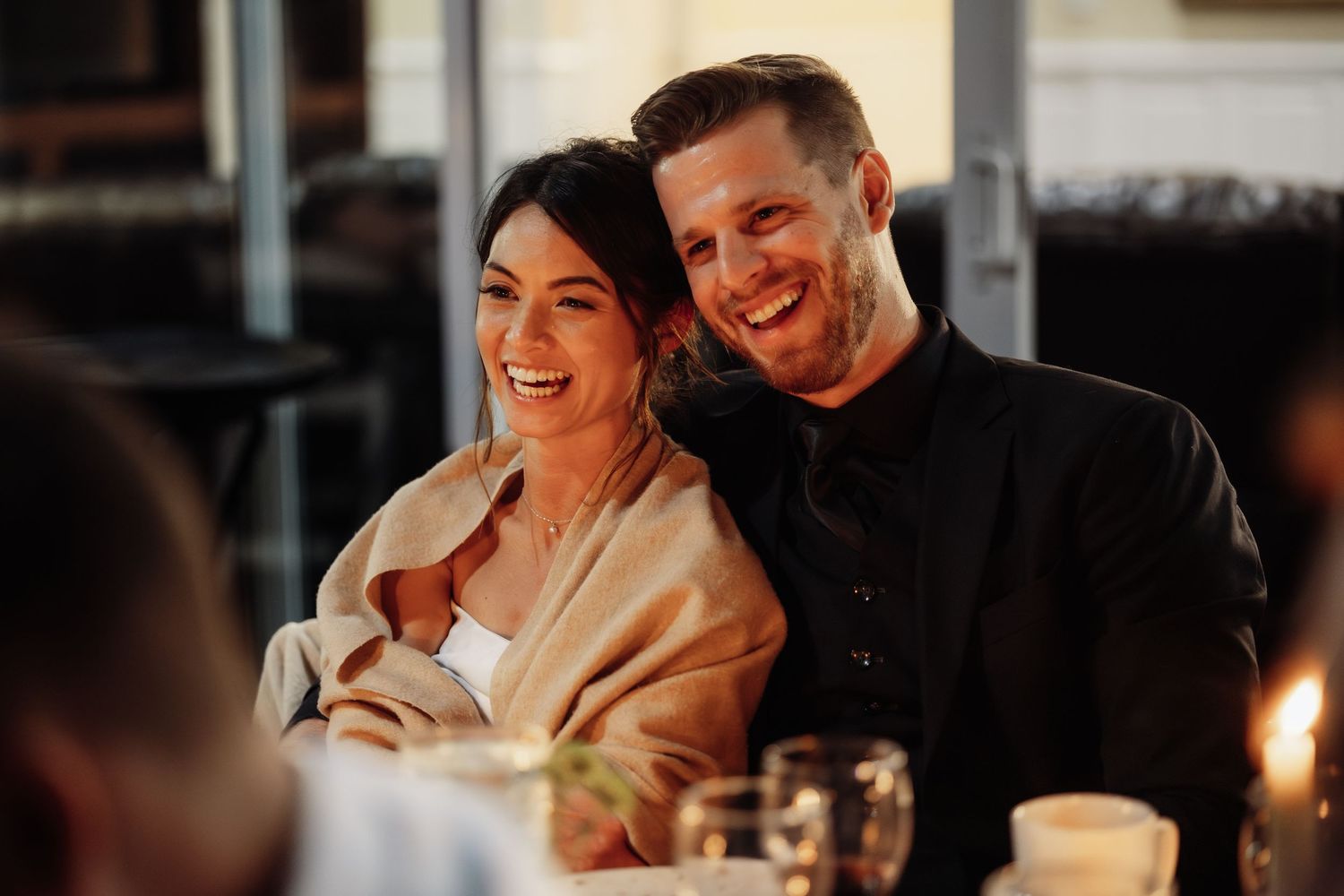 Romantic candlelit wedding reception with elegant table settings and ambient lighting.