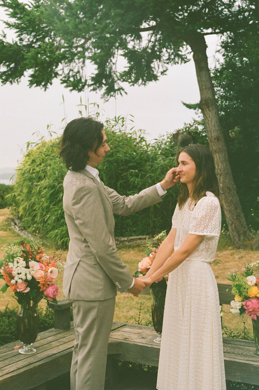 Dancing together on a wooden deck surrounded by flowers and greenery.