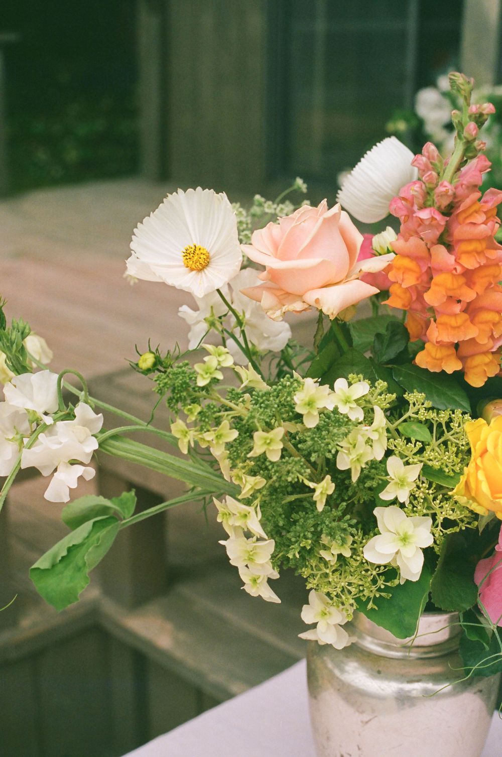 Delicate flower arrangements featuring cosmos, snapdragons and mixed blooms in pastel colors.