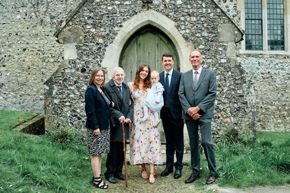A series of outdoor photographs showing small groups of people gathered against a stone church wall.