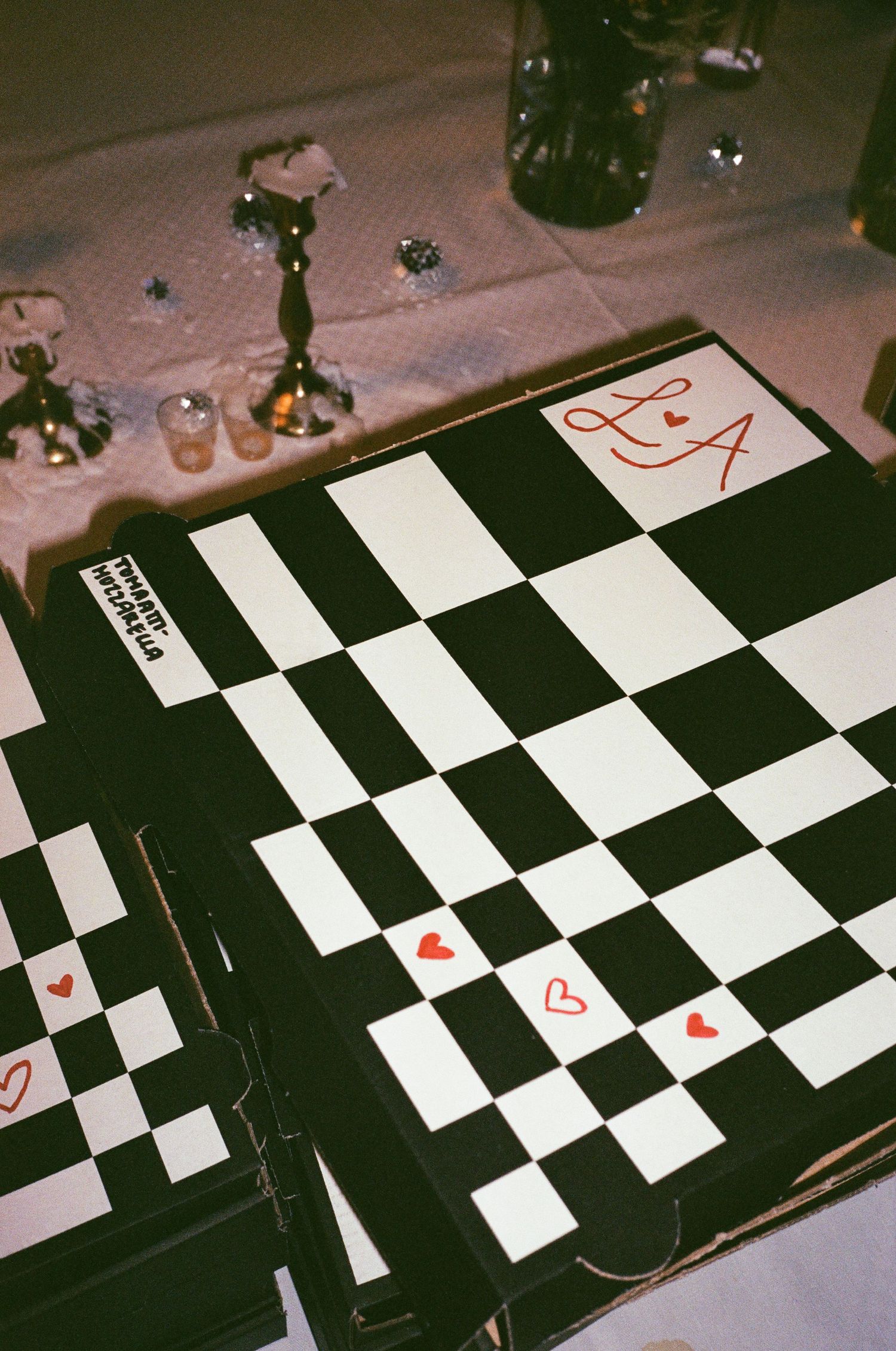 A stylized black and white checkered floor pattern is seen in low lighting with warm tones and shadows.