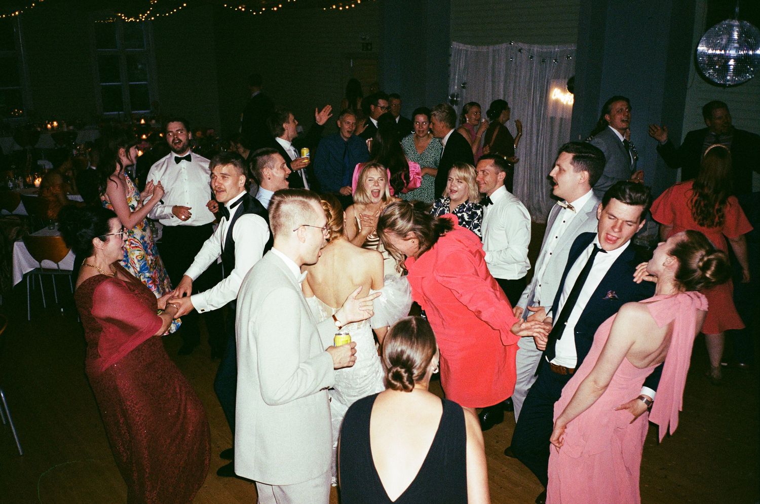 A group of people dancing and socializing at a nighttime celebration or party event.