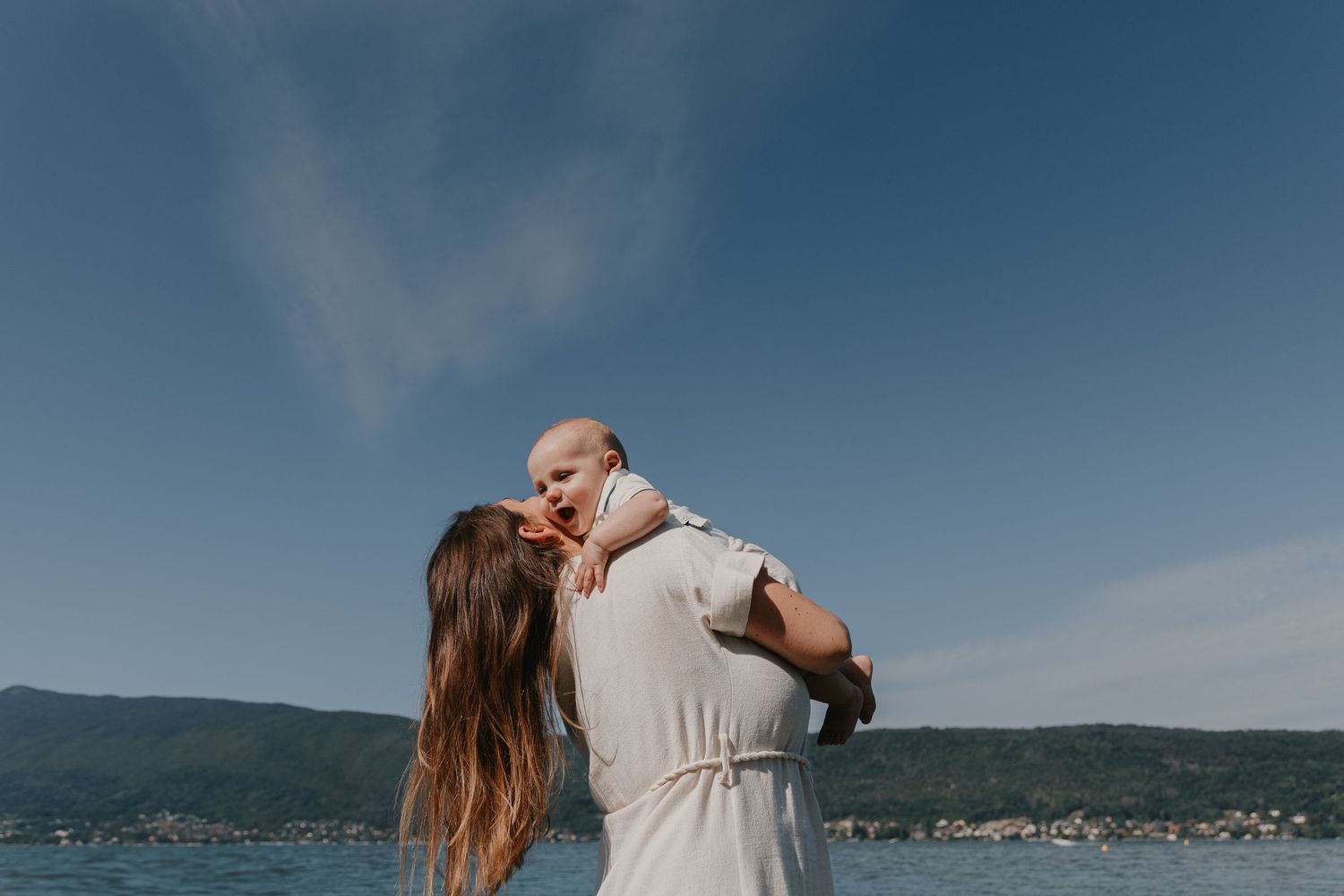 Une maman et son bébé dans un moment tendre lors d'une séance photo famille au bord du lac d'Annecy, photographe famille et mariage Annecy.